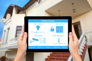 Female hands hold a tablet with system clever house on the backg